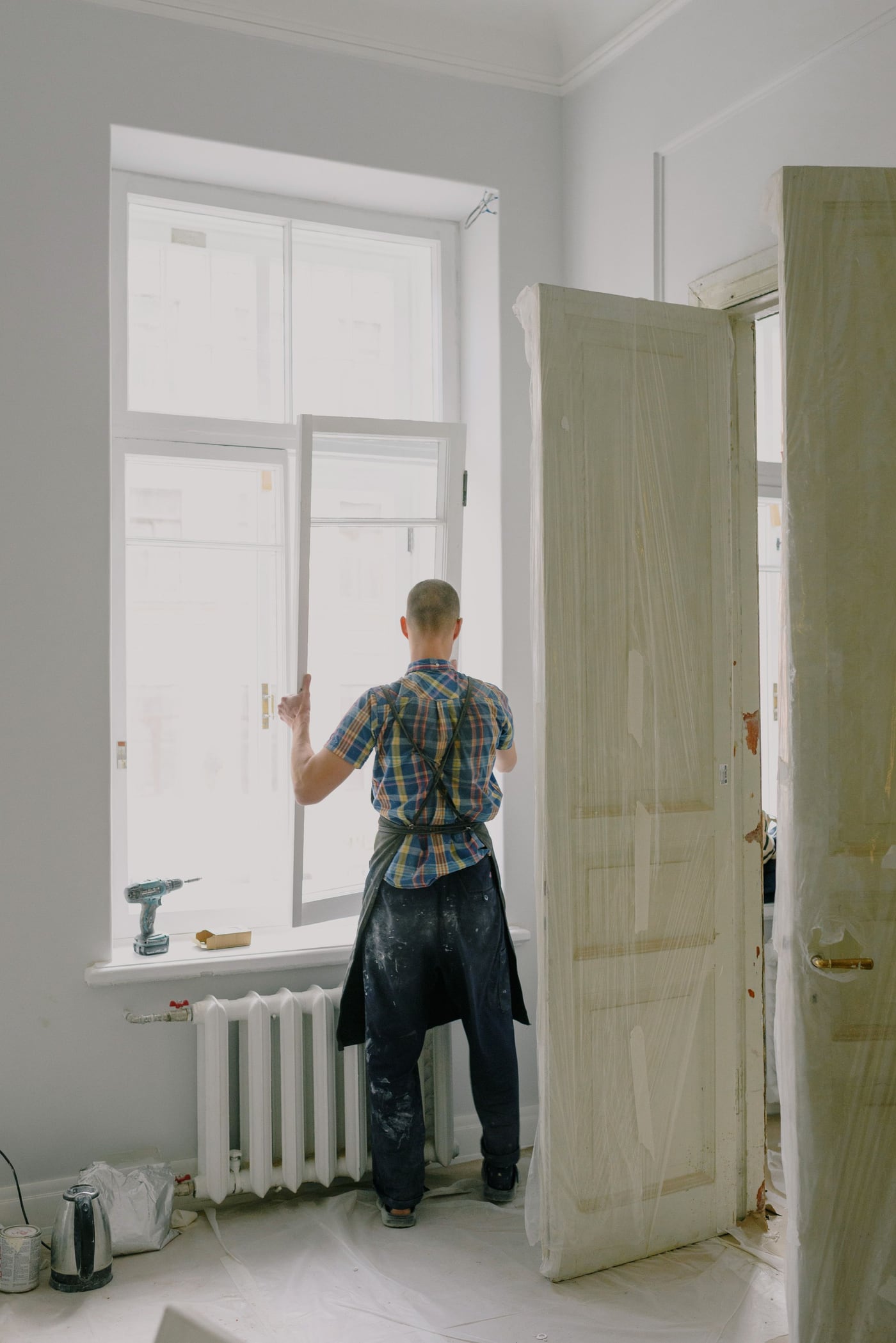 Fensterbauer setzt einen Fensterflügel bei einer Altbausanierung ein