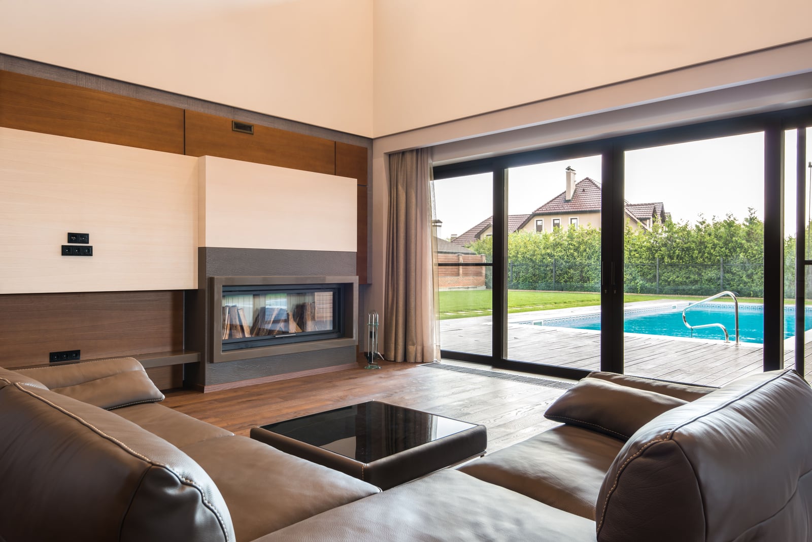 Wohnraum mit großflächiger, vom Fensterbauer eingebauter Glas-Schiebetür mit Blick auf Terrasse und Pool